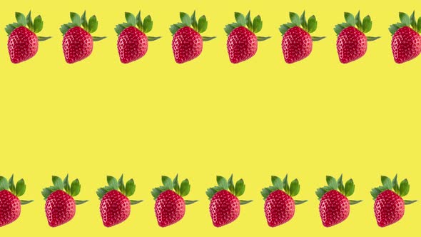 frame made with many fresh red strawberries rotating close-up on a yellow background