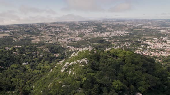 Historic medieval stone ruins of Castle of the Moors in Sintra Portugal, aerial pan shot.