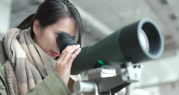 Young Woman observe through telescope