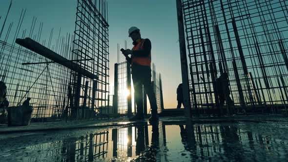 Engineer Is Browsing His Phone on a Roof Building Site. Construction Industry, Construction Project