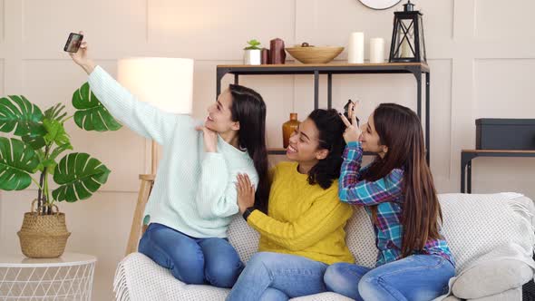 Happy multiracial girls taking selfie photo at home