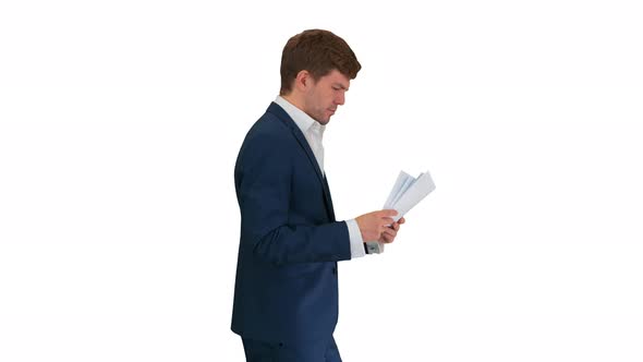 Serious Businessman Reading Documents or Report While Walking on White Background