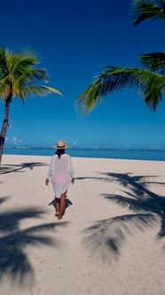 Tropical Beach with Palm Trees and White Sand Blue Ocean and Beach Beds with umbrellaSun Chairs and