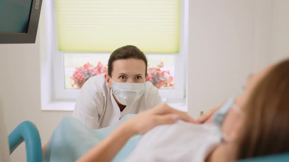 Experienced Female Gynecologist in Lab Coat Face Mask and Gloves Holding Medical