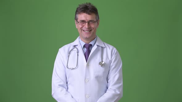 Mature Handsome Man Doctor Against Green Background