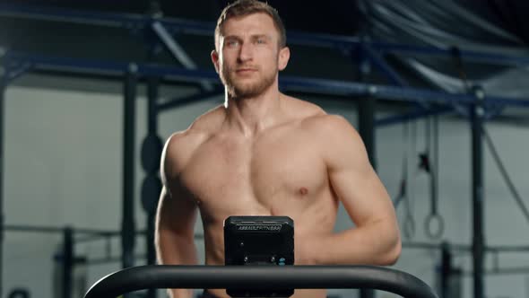 Male athlete athlete is doing cardio training on a treadmill, bodybuilder is running