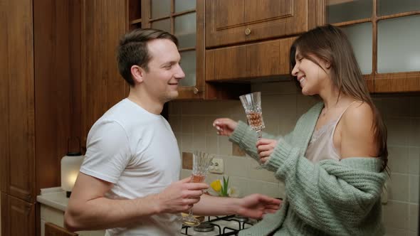 Romantic Couple That Enjoys a Glass of Wine and Relaxing in Kitchen