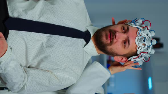 Vertical Video Neurologist Doctor Analysing Brain of Man Using Brainwave Scanning Headset