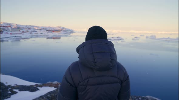 Man In Warm Clothing On Coastline Looking Out To Sea