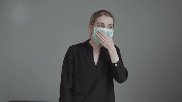 A Blond Woman Coughs in a Mask and Checks the Temperature By Hand