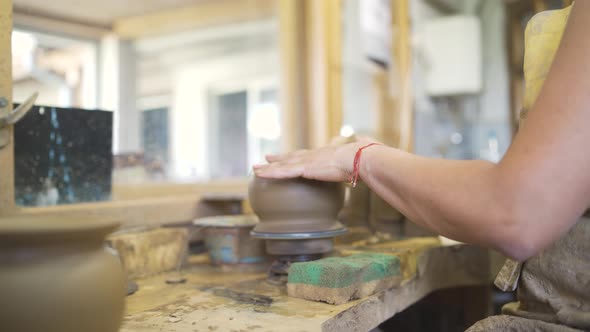 Closeup of a Young Woman Potter Sculpting on a Potter's Wheel a Vase Made of Brown Clay