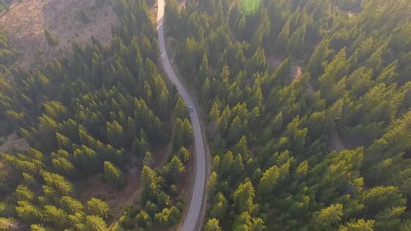 Car driving along the mountain forest road. Aerial view