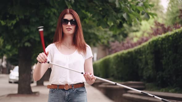 Young Blind Person with Long Cane Walking in a City