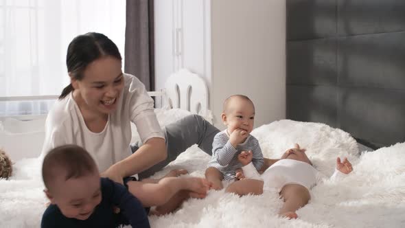 Loving Asian Mom Doing Fun Exercises with Triplets