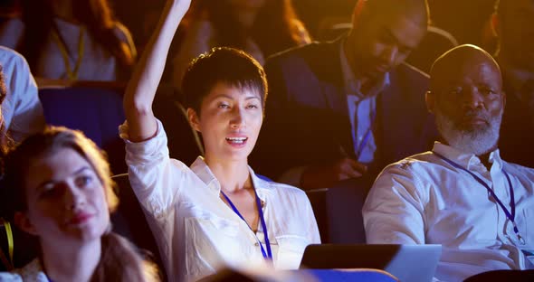 Young Asian businesswoman raising hand in business seminar at auditorium 4k