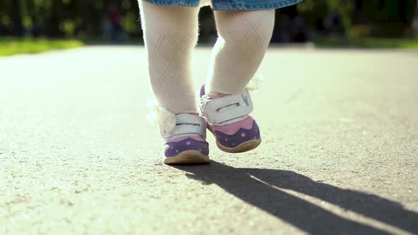 Toddler Girl Feet Stepping on Pathway in Sunny Park alt