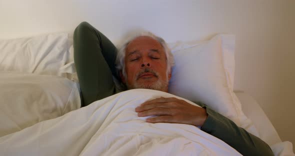 Senior man sleeping on bed in bedroom 4k