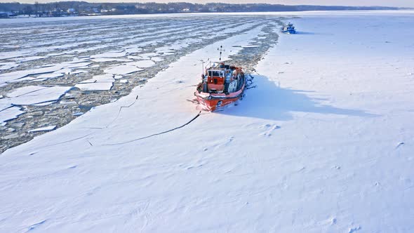 Icebreakers on Vistula river breaking ice. Aerial view of winter.