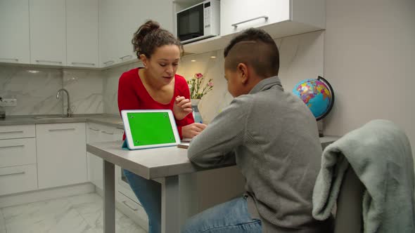 Black Woman Teaching Preteen School Boy Using Digital Tablet Indoors