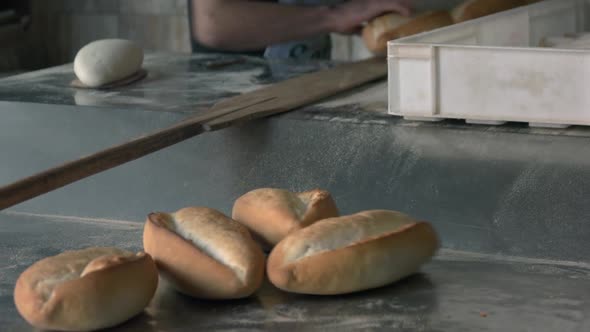 Close Up of Baker Taking Bread Out of Oven