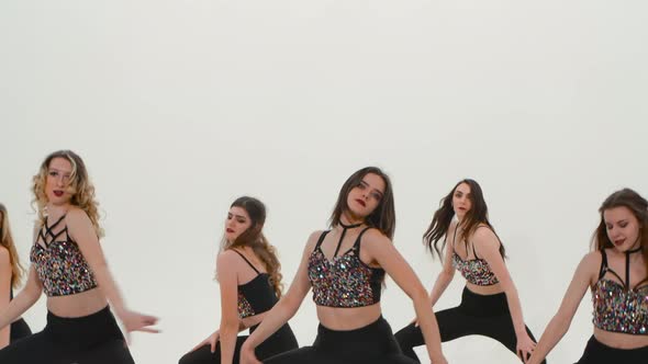 Group of Athletic Cheerleaders in Silver Tops and Black Tight Leggings are Dancing Cheering Dance on