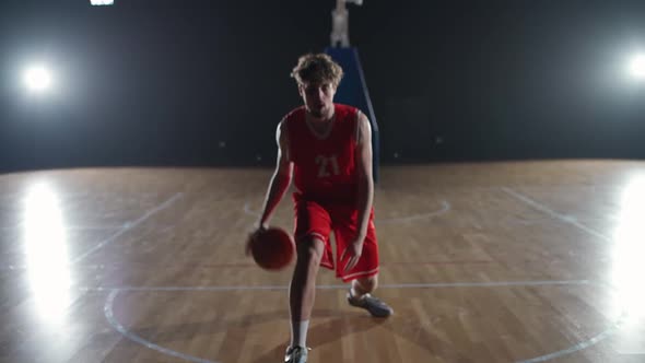 Caucasian Basketball Player Hits the Ball Off the Floor and Warms Up Before the Game Professional