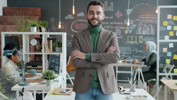 Slow Motion Portrait of Positive Young Businessman Standing in Office Smiling