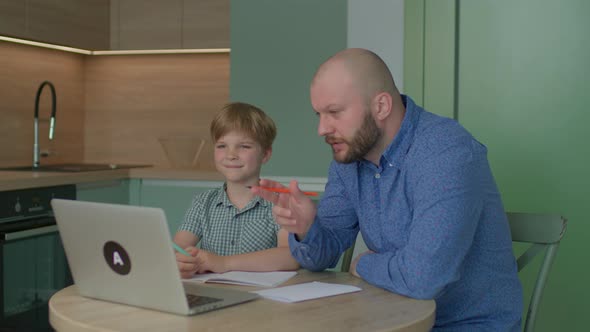 Father Helping His Son with Online Homework