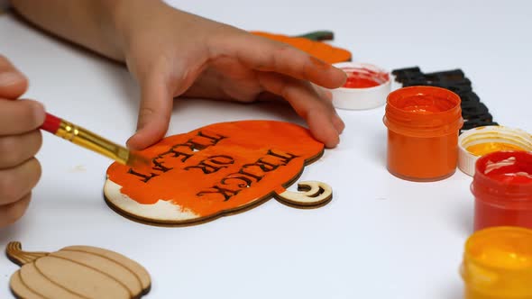 A child draws a pumpkin with his own hands for Halloween.