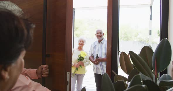 Happy senior biracial couple opening door at retirement home