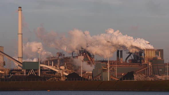 Factory Tata Steel with smoking chimneys on a sunny day in Holland