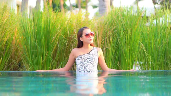 Young asian woman enjoy around outdoor swimming pool for leisure