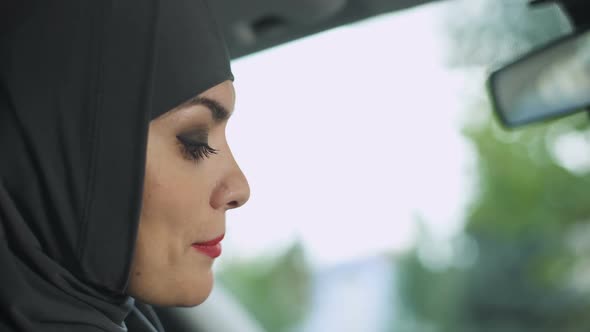 Beautiful Muslim Female Applying Seductive Red Lipstick in Automobile, Feminism