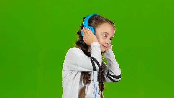 Baby in the Headphones Is Listening To Music. Green Screen
