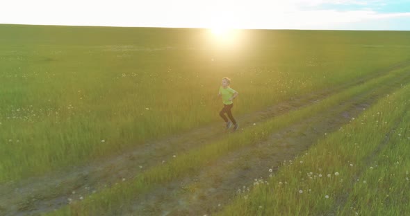 Sporty Child Runs Through a Green Wheat Field