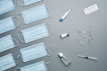 antibiotics and thermometer in laid out over grey background, copy space