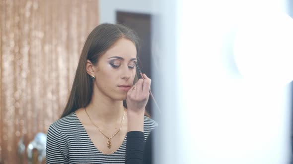 Makeup Artist Blending Eyeshadows To Model in Beauty Salon