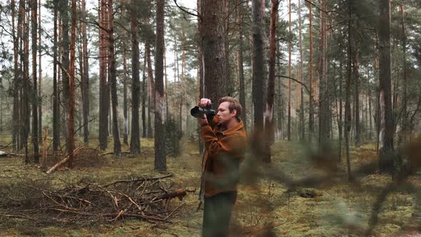 A Young Blond Male Photographer Takes Pictures of Nature