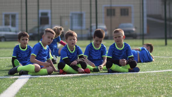 Tired Soccer Players Relaxing During Training