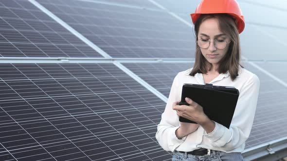 Inspector Engineer Woman Holding Digital Tablet Working in Solar Panels Power Farm