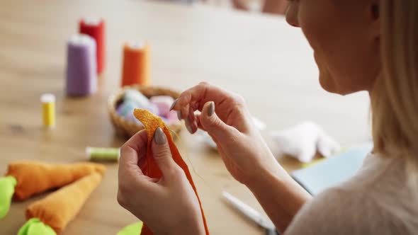 Close up video of woman sews handmade carrots. Shot with RED helium camera in 8K