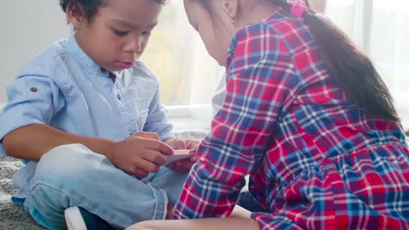 Multiethnic Kids Playing on Smartphone on Bed