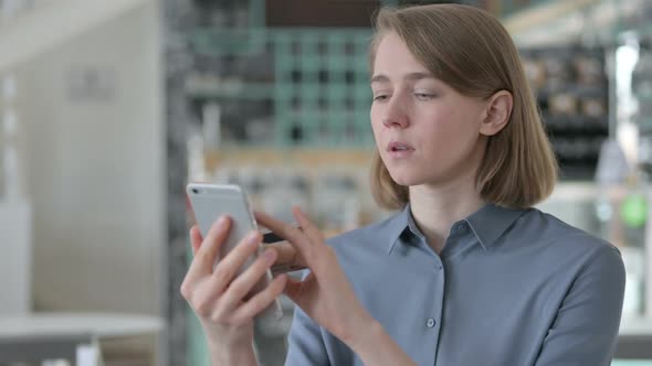 Young Woman with Successful Online Shopping on Smartphone