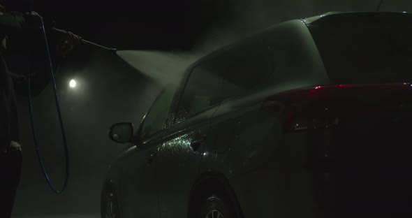 The Guy Is Washing Off the Foam at the Selfservice Car Wash