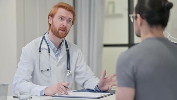 Redhead Male Doctor Discussing Medical Report with Patient