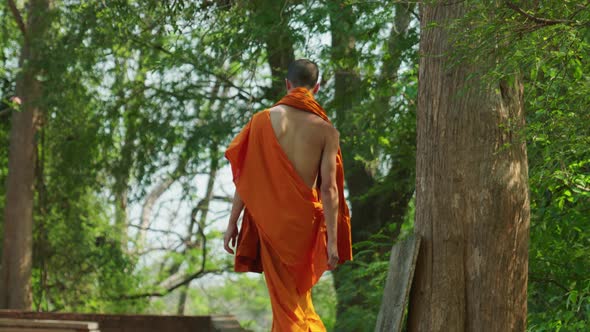 4K Cinematic portrait travel footage of a young Buddhist monk walking on a wall in slow motion at Wa