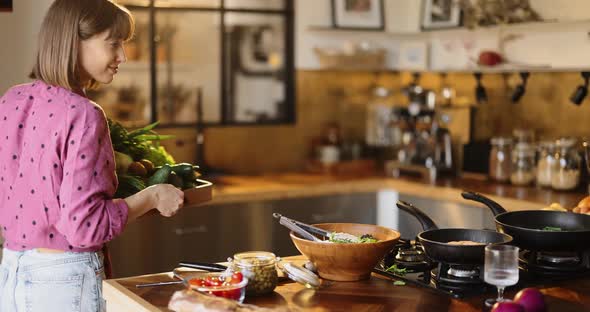 Woman with Vegetables and Greens in the Kitchen