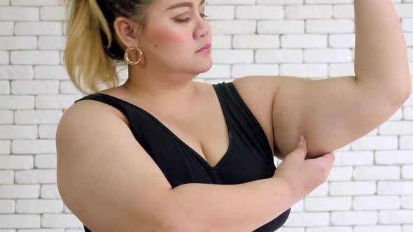 Portrait of an unhappy overweight woman in sportswear