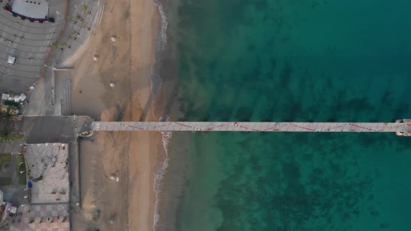 Top-down view of a bridge leading into the ocean by Porto Santo