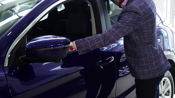 A Young Salesman Stroking the Car